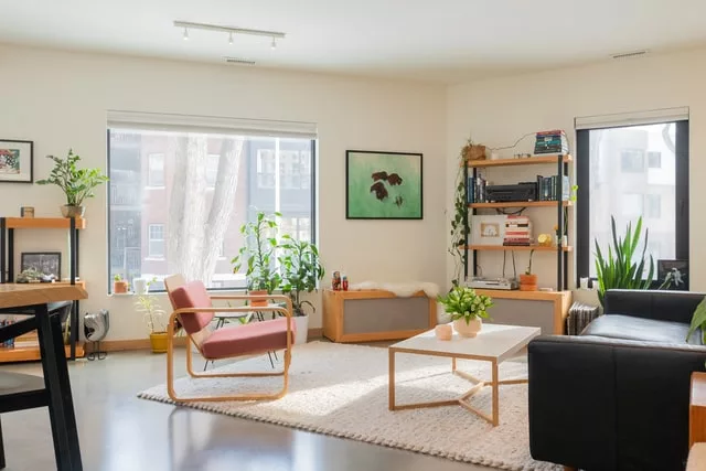 Eclectic living room with a vintage velvet couch and abstract neon wall art.